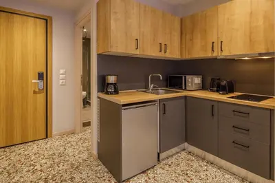 a kitchen with wooden cabinets and a counter top at Cozy loft at Little Kook's alley, Psirry heart in Athens
