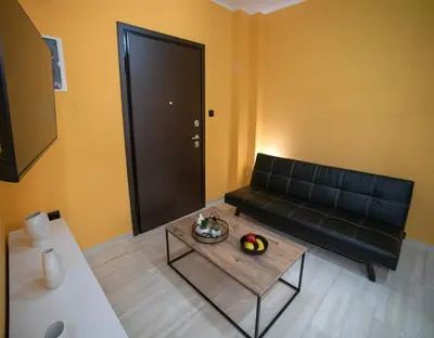 a living room with a black couch and a table at Smart Studio with Self Check-in in Athens