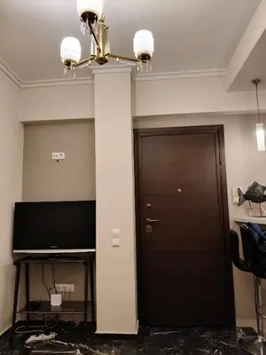 a hallway with a black door and a chandelier at A perfect place - close to Acropolis & Seacoast in Athens