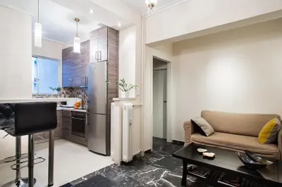 a living room with a couch and a kitchen at A perfect place - close to Acropolis & Seacoast in Athens