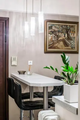 a dining room with a white table and black chairs at A perfect place - close to Acropolis & Seacoast in Athens