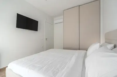 a white bedroom with two beds and a flat screen tv at M58 Pool Residence - Glyfada Central - Miltiadou 58 by K&M in Athens