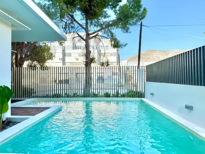 a swimming pool in front of a fence at M58 Pool Residence - Glyfada Central - Miltiadou 58 by K&M in Athens
