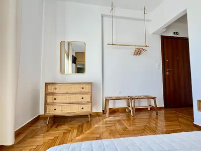 a bedroom with a bed and a dresser and a mirror at Rooftop Oasis - Design Studio with Acropolis View in Athens