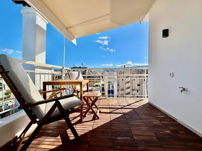 a balcony with a table and chairs on a building at Rooftop Oasis - Design Studio with Acropolis View in Athens