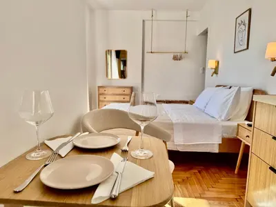 a room with a table with plates and wine glasses at Rooftop Oasis - Design Studio with Acropolis View in Athens