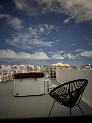 a chair on a roof with a view of a city at Krezias Apartments K1 Acropolis View ! in Athens