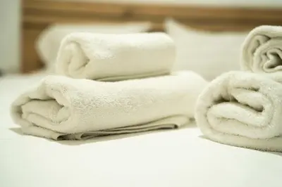 a pile of towels sitting on top of a bed at Cozy Gem in Athens in Athens