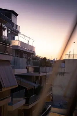 a view of a building with the sunset in the background at Cozy Gem in Athens in Athens