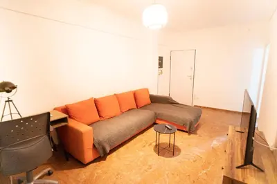 a living room with a couch with orange pillows at Cozy Gem in Athens in Athens