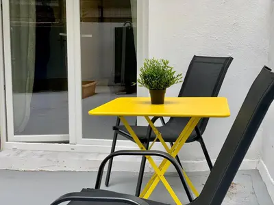 a yellow table with two chairs and a potted plant at Citrus in Athens