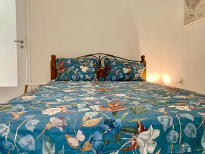 a bedroom with a bed with a blue floral bedspread at Citrus in Athens