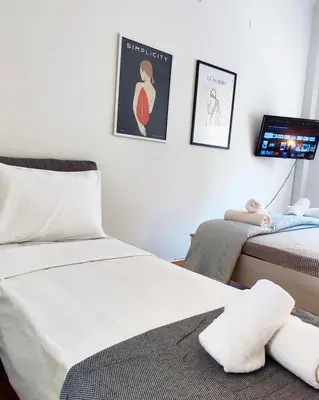 a bedroom with two beds and a flat screen tv at One bedroom apartment in Thissio in Athens