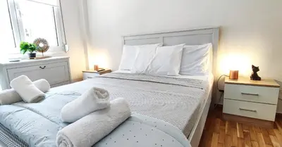 a bedroom with a large bed with white sheets and pillows at One bedroom apartment in Thissio in Athens