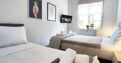 a small bedroom with two beds and a tv at One bedroom apartment in Thissio in Athens