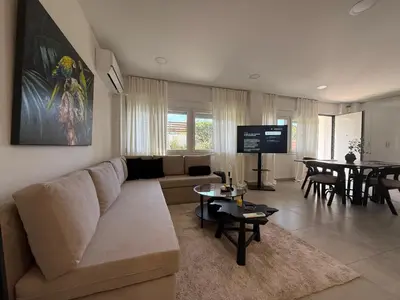 a living room with a couch and a table at Beachfrond apartment in Voula in Athens