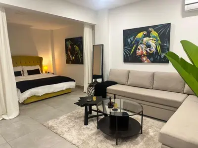 a living room with a couch and a bed at Beachfrond apartment in Voula in Athens