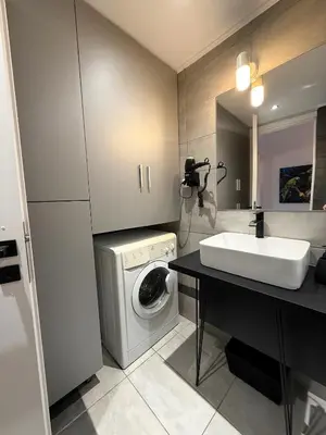 a bathroom with a sink and a washing machine at Beachfrond apartment in Voula in Athens