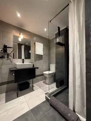a bathroom with a sink and a toilet and a shower at Beachfrond apartment in Voula in Athens
