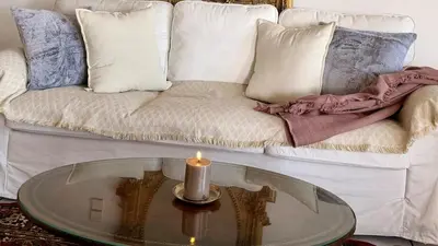 a living room with a couch with a candle on a glass table at Promenade Piraeus in Piraeus