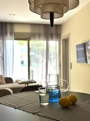 a table with a glass of water and some fruit on it at Brand New Apartment next to Varkiza Beach in Vari