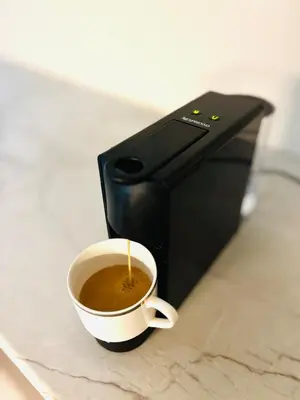 a cup of coffee sitting in front of a microwave at Brand New Apartment next to Varkiza Beach in Vari