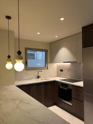 a kitchen with a sink and a tv on the wall at Brand New Apartment next to Varkiza Beach in Vari