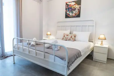 a bedroom with a white bed and two lamps at Casa Anavyssos in Anavissos