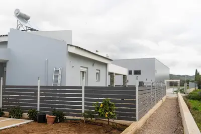 a white house with a fence in front of it at Casa Anavyssos in Anavissos