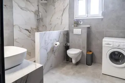 a bathroom with a toilet sink and a washing machine at Casa Anavyssos in Anavissos