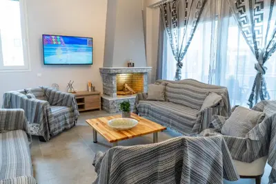 a living room with couches and a fireplace at Casa Anavyssos in Anavissos