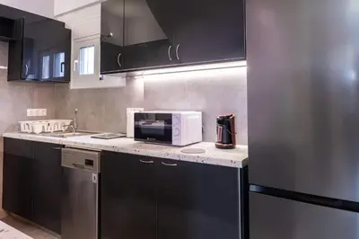 a kitchen with black cabinets and a microwave on a counter at Casa Anavyssos in Anavissos