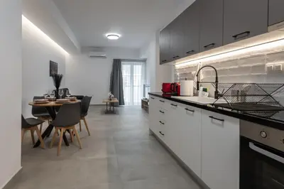 a kitchen with white cabinets and a dining room at M20 Athens Apartments in Athens