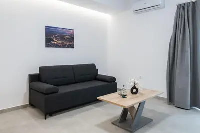 a black couch in a living room with a table at M20 Athens Apartments in Athens