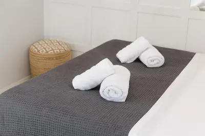 a group of rolled towels sitting on top of a bed at Elysium Heated Jacuzzi with Acropolis View in Athens