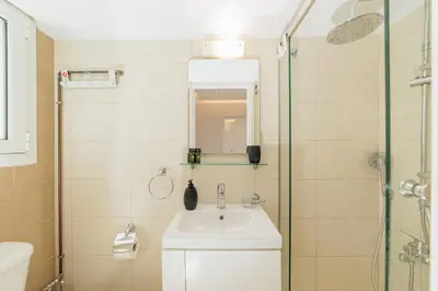 a bathroom with a sink and a shower at Elysium Heated Jacuzzi with Acropolis View in Athens