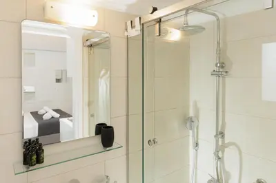 a bathroom with a shower with a glass door at Elysium Heated Jacuzzi with Acropolis View in Athens