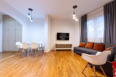 a living room with a couch and a table and chairs at HeKo Collection Athens Center 1 in Athens