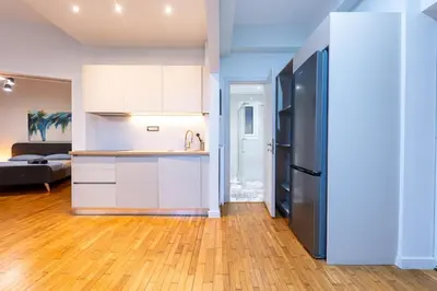 a kitchen with white cabinets and a black refrigerator at HeKo Collection Athens Center 1 in Athens