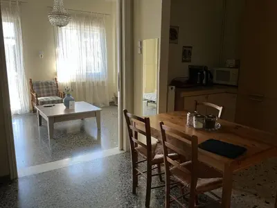 a kitchen and dining room with a wooden table and chairs at Eleni's apartment in Piraeus