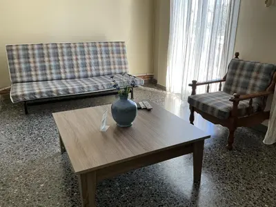 a living room with a couch and a vase on a coffee table at Eleni's apartment in Piraeus