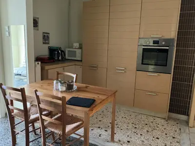 a kitchen with a wooden table with chairs and an oven at Eleni's apartment in Piraeus