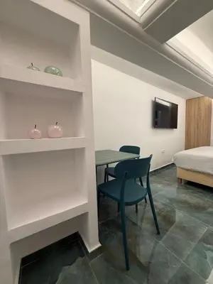 a room with a table and a bed and a table and chairs at City Center Green Lux Studio in Athens