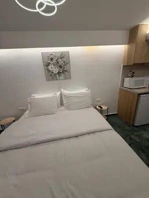 a bed with white sheets and pillows in a room at City Center Green Lux Studio in Athens