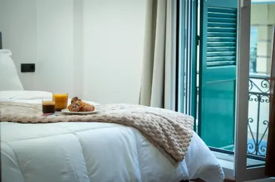 a bed with a blanket and two glasses of orange juice at Klitiou 7 Boutique Hotel in Athens