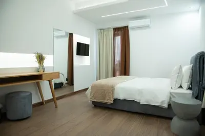 a bedroom with a bed and a desk and a television at Klitiou 7 Boutique Hotel in Athens