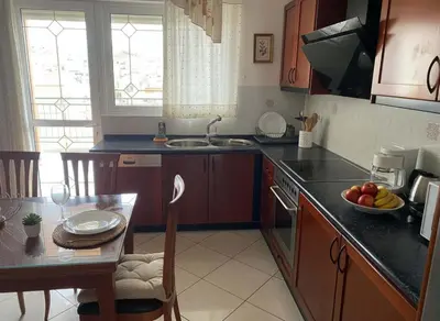 a kitchen with a table and a bowl of fruit on the counter at Triple Nest Maisonette - Korydallos by ΜΡS in Piraeus