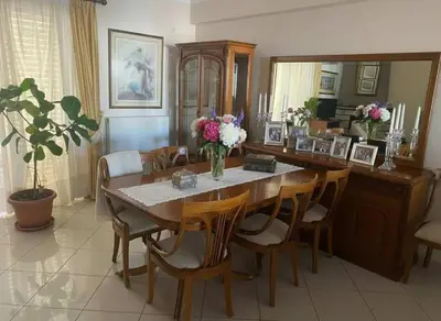 a dining room with a wooden table and chairs at Triple Nest Maisonette - Korydallos by ΜΡS in Piraeus