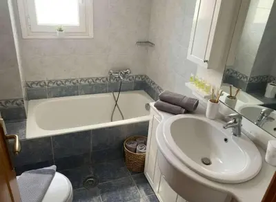 a bathroom with a tub and a sink and a toilet at Triple Nest Maisonette - Korydallos by ΜΡS in Piraeus