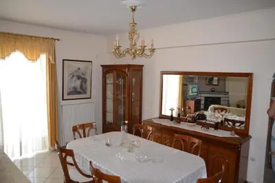 a dining room with a table and a kitchen at Triple Nest Maisonette - Korydallos by ΜΡS in Piraeus